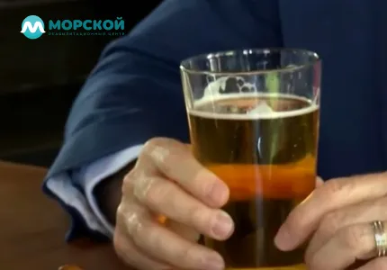 Мужчина держит в руке стакан пиво